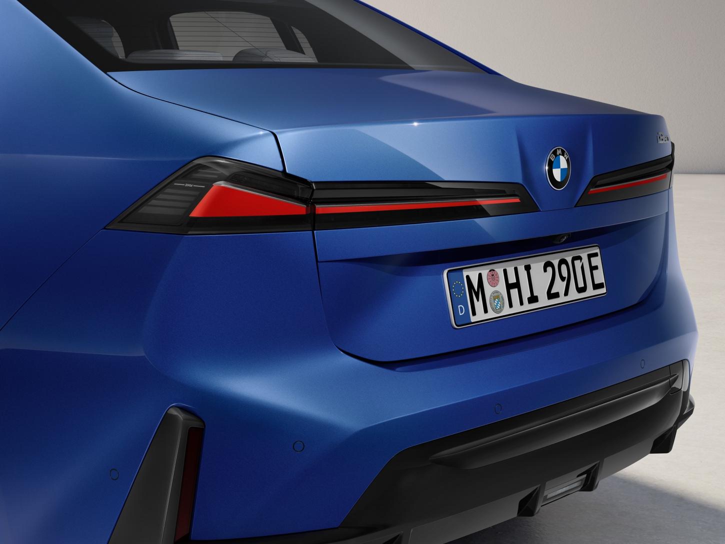Close-up of the BMW i3 sedan's rear with its horizontal taillights switched on