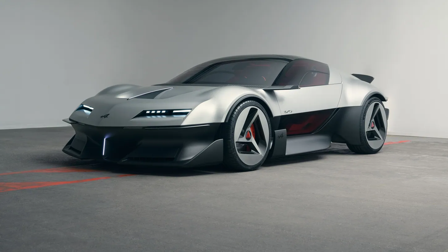 Silver and black Alpine A310 VISION concept coupe with triangular A-shaped wheels, photographed from the front three-quarter angle in a grey studio