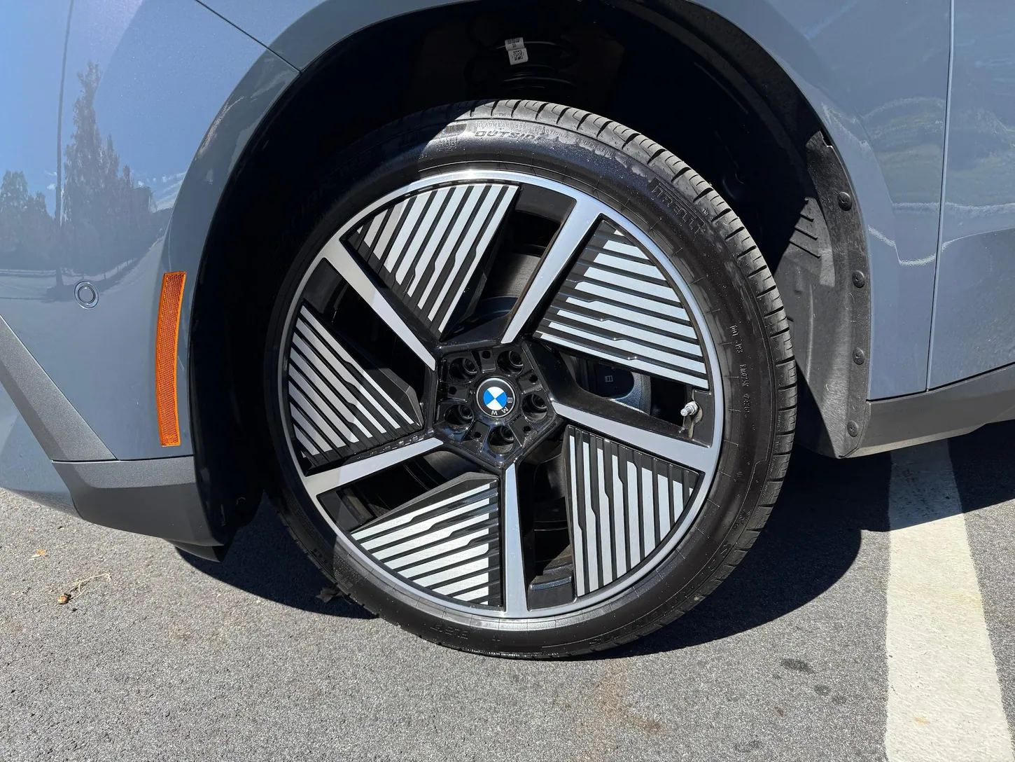 Close-up of a BMW iX3 aero wheel with a Pirelli tire and the front fender