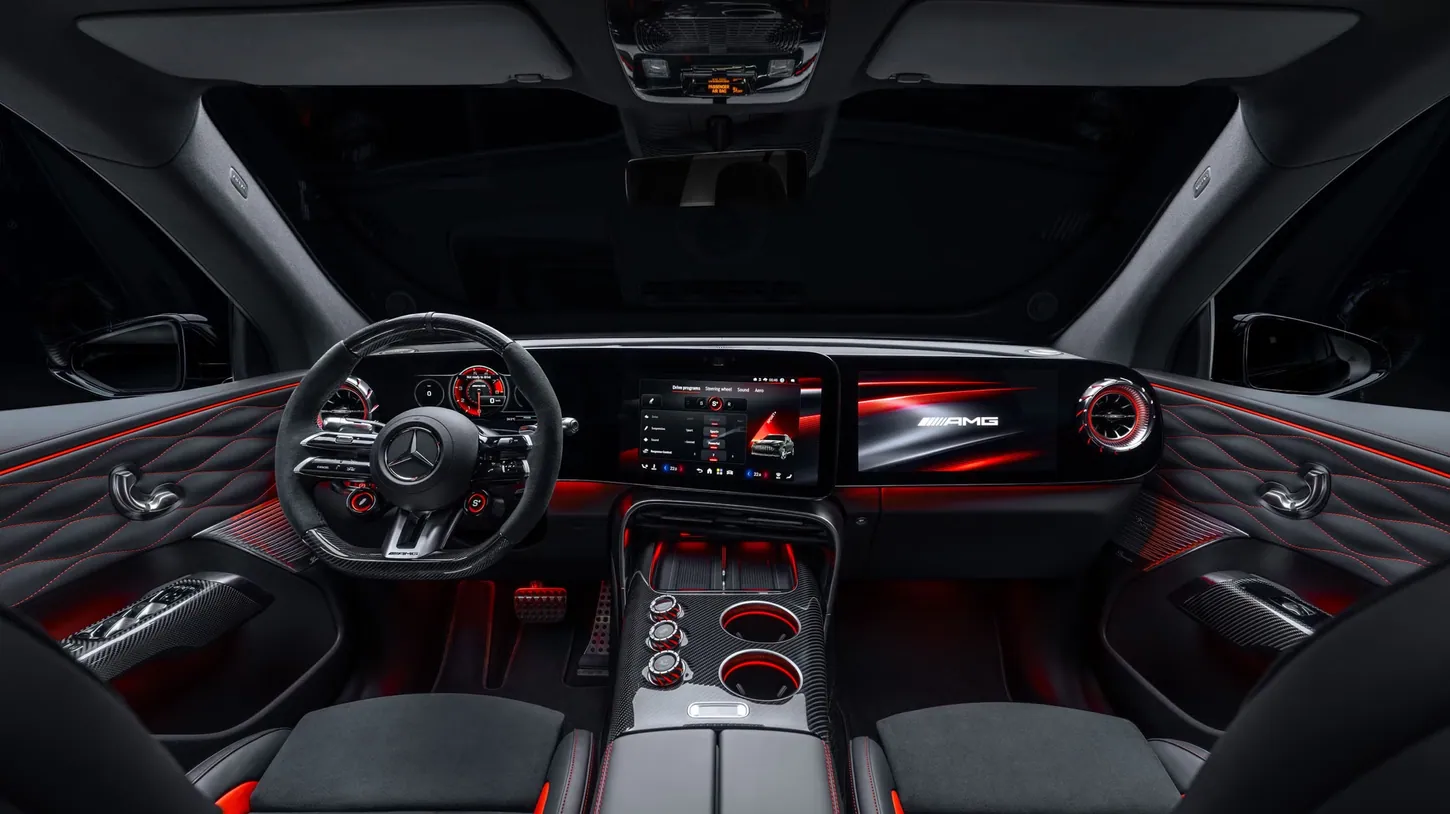 Dark Mercedes-AMG GT SUV cockpit with red ambient lighting, a 10.2-inch driver display, 14-inch center screen angled toward the driver and passenger screen