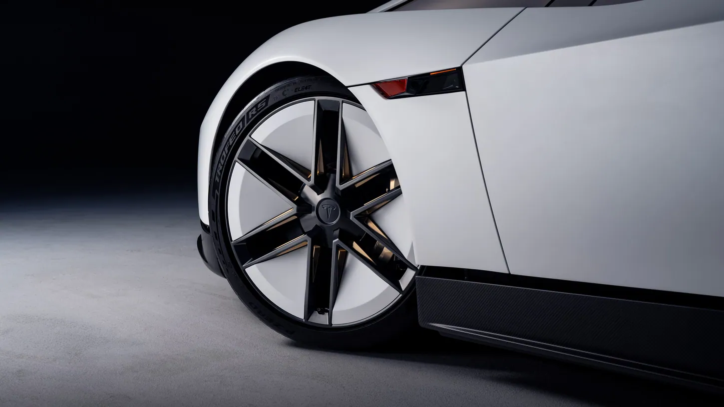 Close-up of the Tesla Roadster front wheel with six thin black spokes over white inserts, a Pirelli P Zero Trofeo RS tire and a red side marker light