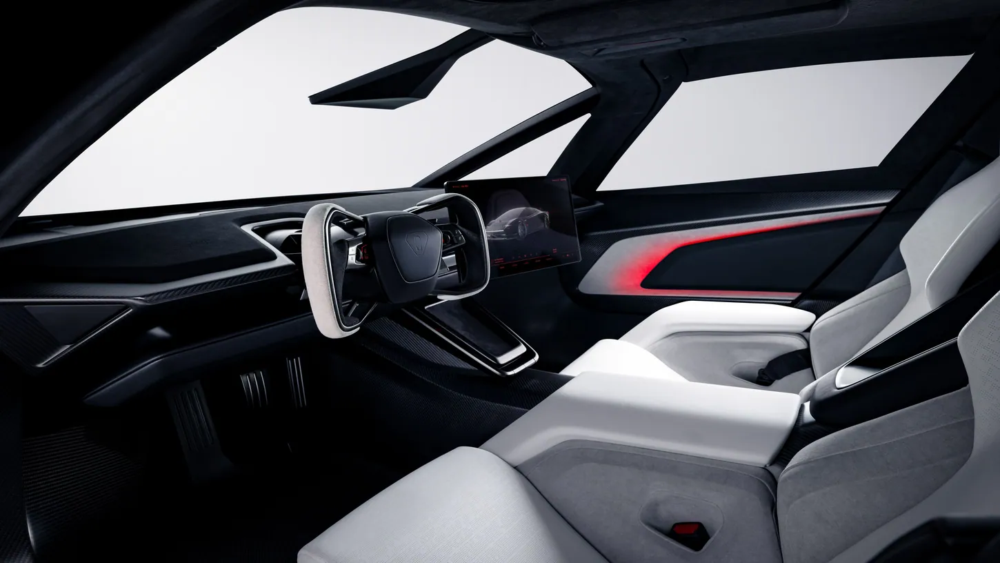 Interior of the new Tesla Roadster seen from the passenger side, with a white yoke, a dash-mounted touchscreen and two white sport seats