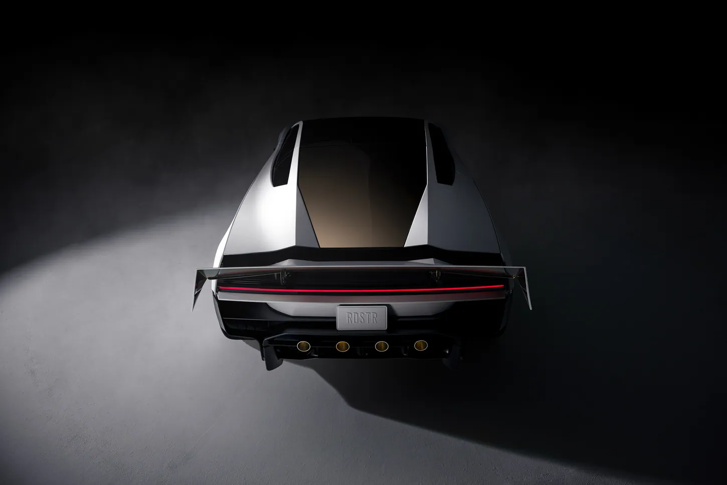 Tesla Roadster seen from above and behind in a dark studio, with gold-tinted rear glass, a raised wing and four thruster nozzles