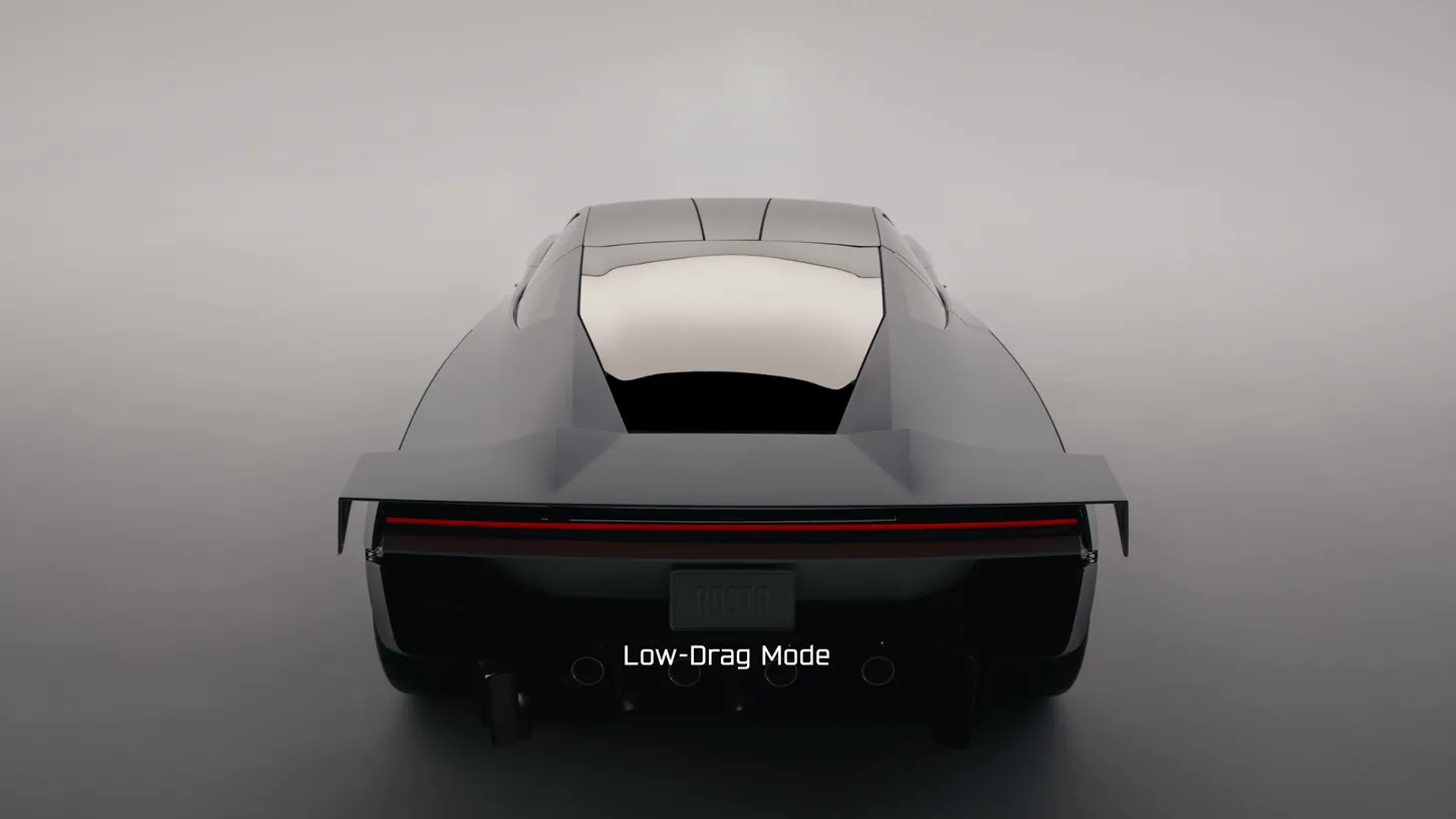 Rear view of a dark gray Tesla Roadster in a studio with its wing spread flat above the red taillight bar, labeled Low-Drag Mode