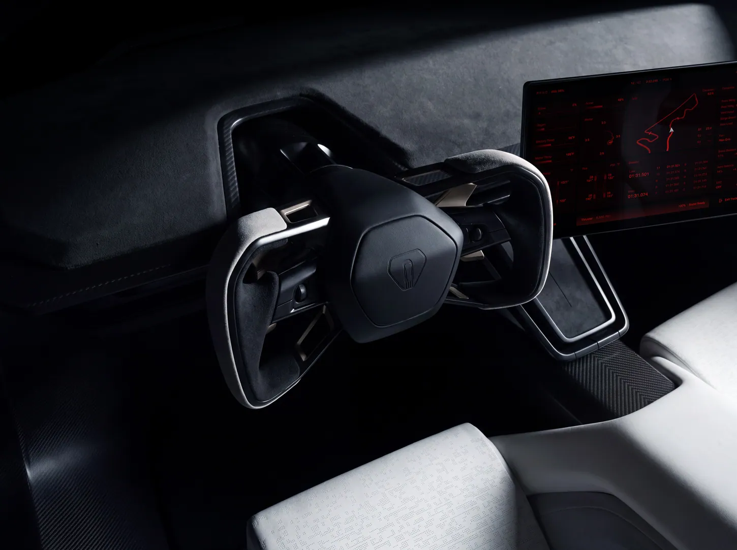 Close-up of the Tesla Roadster gray microsuede yoke in front of a red track-mode screen showing a circuit map, lap times and a thruster pressure readout