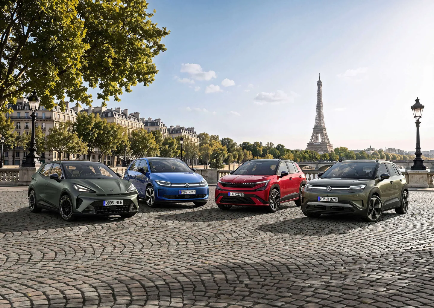 Four small electric SUVs and hatchbacks from Cupra, Volkswagen and Skoda parked on cobblestones in Paris with the Eiffel Tower behind them